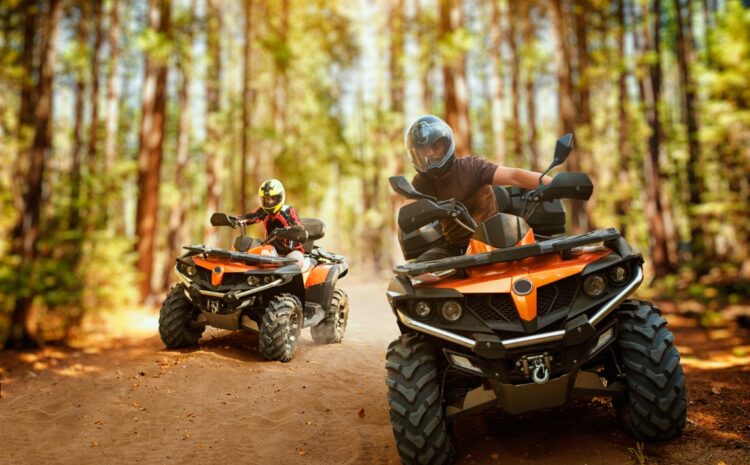 Two atv riders in helmets, speed race in forest, front view. Riding on quad bike, extreme sport and travelling, quadbike offroad adventure